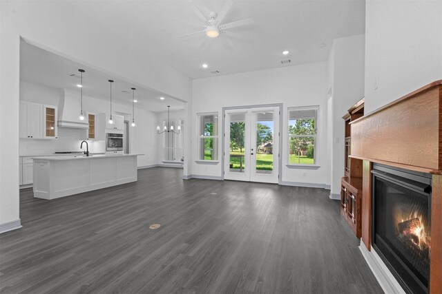 29 Westwood Dr W, Trinity, TX 75862 - unfurnished living room featuring a glass covered fireplace, recessed lighting, a ceiling fan, dark wood-style floors, and a towering ceiling