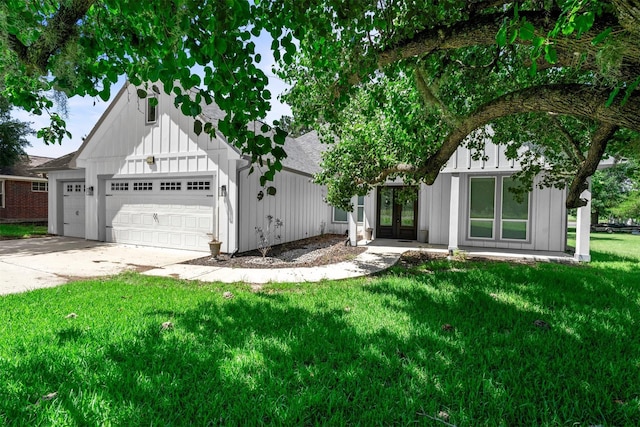 29 Westwood Dr W, Trinity, TX 75862 - view of front facade featuring french doors, a front yard, an attached garage, board and batten siding, and concrete driveway
