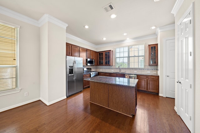 878 Fisher St, Houston, TX 77018 - kitchen with appliances with stainless steel finishes, tasteful backsplash, a kitchen island, dark wood-style floors, and dark stone counters
