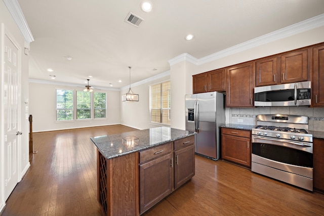 878 Fisher St, Houston, TX 77018 - kitchen with stainless steel appliances, dark wood finished floors, dark stone countertops, decorative backsplash, and ornamental molding