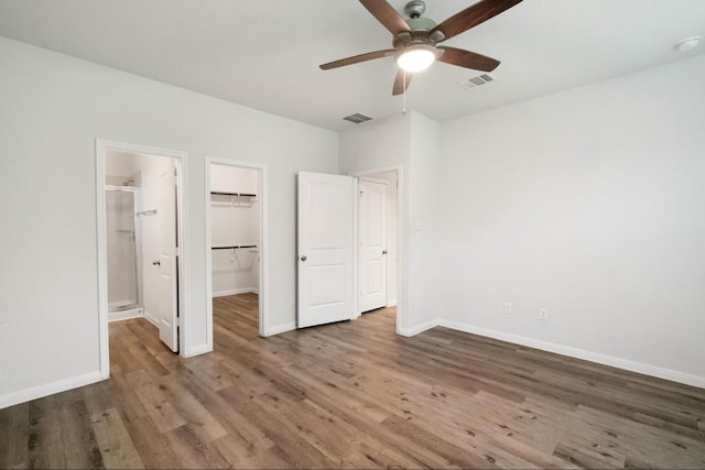 17531 Cuthbert St, Humble, TX 77346 - unfurnished bedroom featuring wood finished floors, a walk in closet, a closet, ceiling fan, and ensuite bathroom