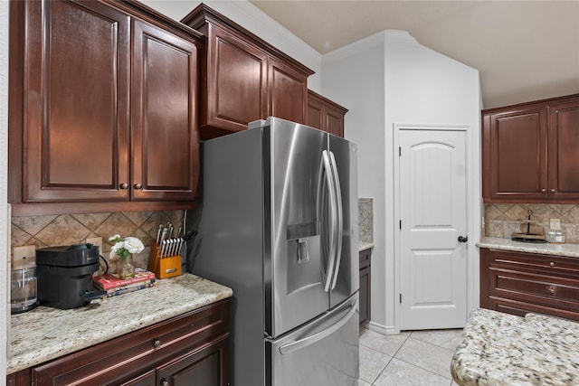4202 Carnes Ct S, College Station, TX 77845 - kitchen featuring stainless steel fridge, light tile patterned floors, decorative backsplash, crown molding, and light stone counters