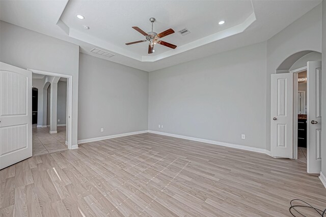 30806 Academy Trace Dr, Spring, TX 77386 - unfurnished room featuring arched walkways, ceiling fan, a tray ceiling, recessed lighting, and light wood-type flooring