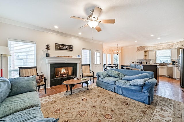 12811 E Conquistador, Galveston, TX 77554 - living area featuring ceiling fan, ornamental molding, wood finished floors, a chandelier, and a warm lit fireplace