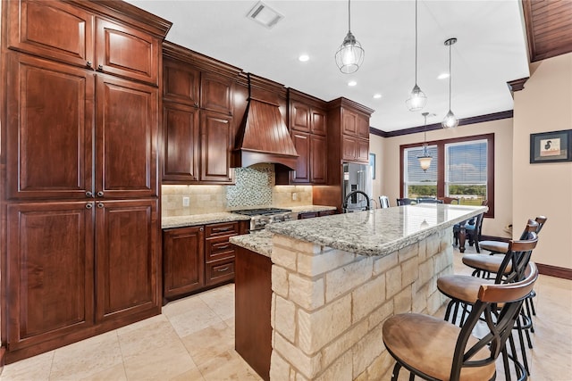 2830 Airport Rd, Brenham, TX 77833 - kitchen featuring custom range hood, high end fridge, backsplash, an island with sink, and light stone countertops