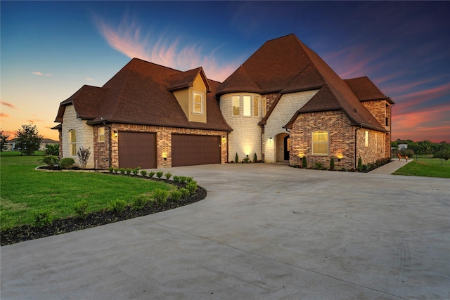 2830 Airport Rd, Brenham, TX 77833 - french provincial home featuring stone siding, a garage, concrete driveway, a front yard, and roof with shingles