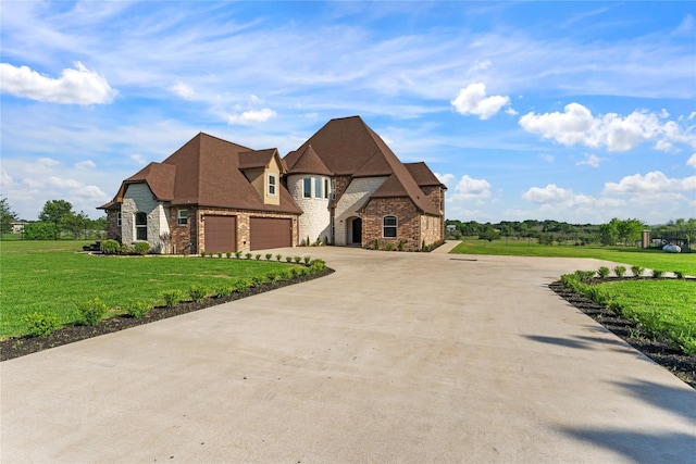 2830 Airport Rd, Brenham, TX 77833 - french country inspired facade featuring stone siding, concrete driveway, a front yard, brick siding, and an attached garage