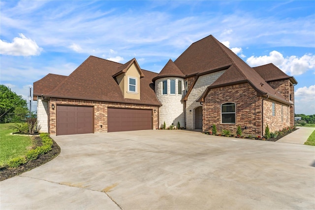 2830 Airport Rd, Brenham, TX 77833 - french country style house with concrete driveway, a garage, stone siding, roof with shingles, and brick siding