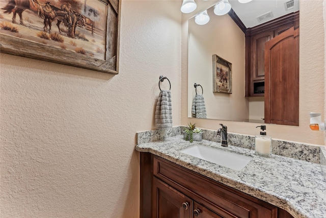 2830 Airport Rd, Brenham, TX 77833 - bathroom with a textured wall, vanity, and crown molding