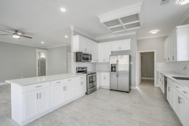 6302 Laver Love Dr, Spring, TX 77379 - kitchen featuring appliances with stainless steel finishes, ornamental molding, backsplash, a ceiling fan, and white cabinets