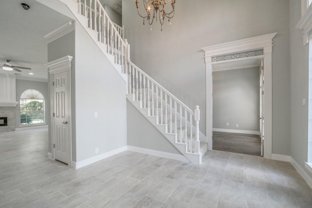 6302 Laver Love Dr, Spring, TX 77379 - stairway with crown molding, a stone fireplace, ceiling fan, and a chandelier