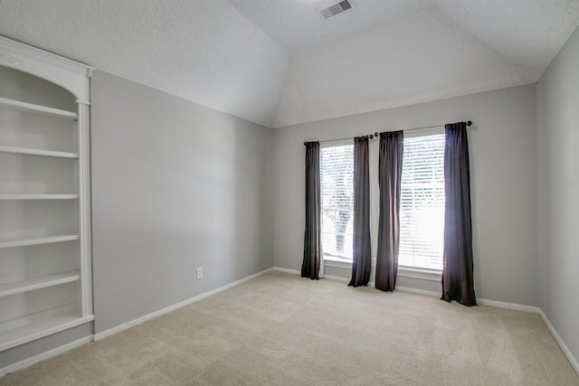 6302 Laver Love Dr, Spring, TX 77379 - empty room with light colored carpet, a textured ceiling, and vaulted ceiling