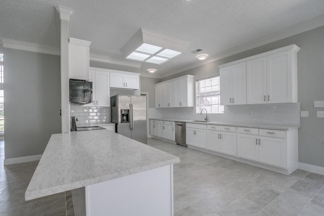 6302 Laver Love Dr, Spring, TX 77379 - kitchen featuring appliances with stainless steel finishes, ornamental molding, a textured ceiling, backsplash, and white cabinets