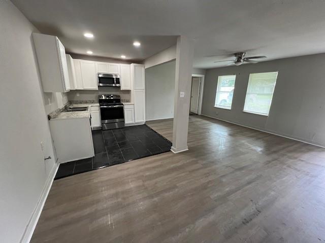 2227 Westway St, Orange, TX 77630 - kitchen featuring stainless steel appliances, open floor plan, dark wood-style floors, ceiling fan, and white cabinetry