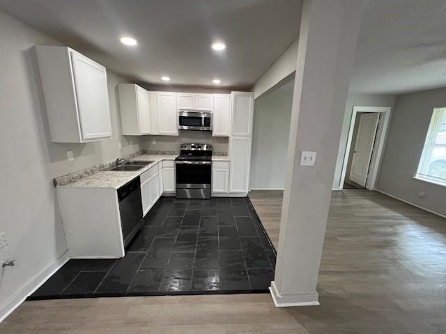 2227 Westway St, Orange, TX 77630 - kitchen with stainless steel appliances, white cabinets, light countertops, recessed lighting, and dark wood finished floors