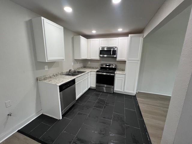2227 Westway St, Orange, TX 77630 - kitchen with stainless steel appliances, white cabinets, light countertops, and recessed lighting