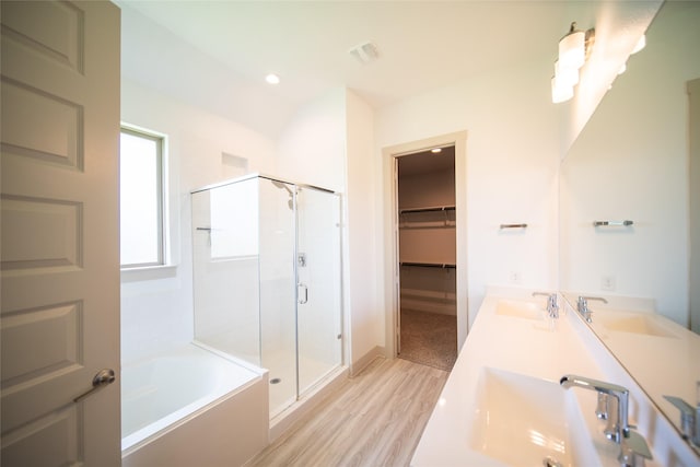 127 Dorado Dr, Friendswood, TX 77546 - bathroom featuring a stall shower, a garden tub, wood finished floors, double vanity, and a walk in closet