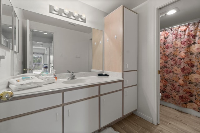 12800 Melville Dr Unit B207, Montgomery, TX 77356 - full bathroom with vanity, wood finish floors, and a shower with shower curtain