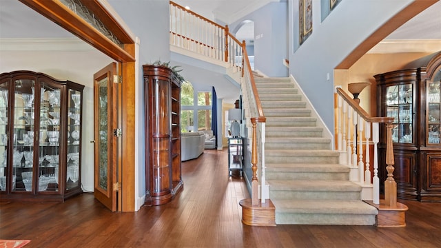 37703 Edgewater Dr, Pinehurst, TX 77362 - entryway with ornamental molding, a towering ceiling, stairway, hardwood / wood-style flooring, and arched walkways