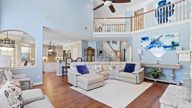37703 Edgewater Dr, Pinehurst, TX 77362 - living room with ceiling fan, crown molding, arched walkways, wood finished floors, and a high ceiling