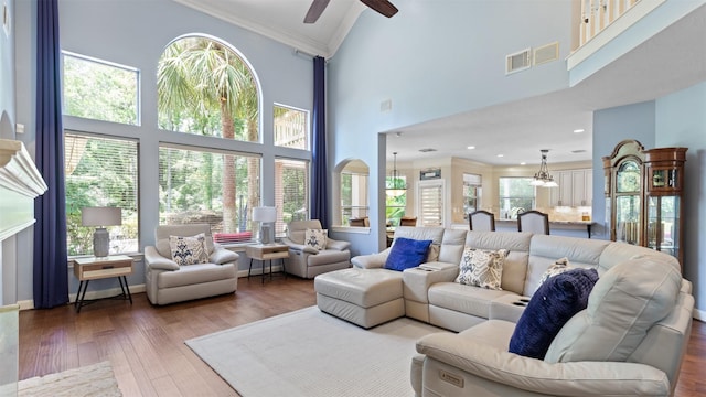 37703 Edgewater Dr, Pinehurst, TX 77362 - living area with a chandelier, crown molding, a ceiling fan, a high ceiling, and wood finished floors