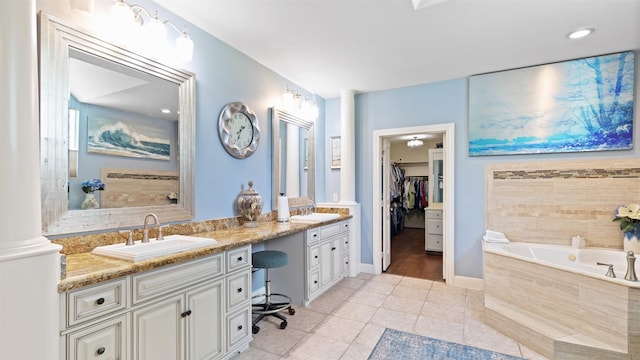 37703 Edgewater Dr, Pinehurst, TX 77362 - bathroom featuring double vanity, a garden tub, tile patterned flooring, and a spacious closet