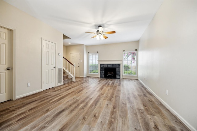 3200 Bellefontaine St Unit 72, Houston, TX 77025 - unfurnished living room featuring stairway, ceiling fan, wood finished floors, and a fireplace