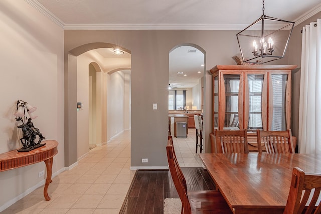 2954 Smokey Forest Ln, Spring, TX 77386 - dining area with arched walkways, a chandelier, ornamental molding, and light tile patterned floors