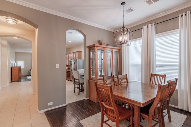 2954 Smokey Forest Ln, Spring, TX 77386 - dining area with arched walkways, crown molding, light wood-style flooring, and a chandelier