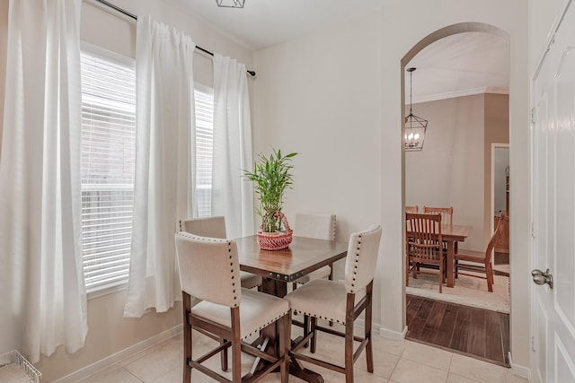 2954 Smokey Forest Ln, Spring, TX 77386 - dining room with arched walkways, light tile patterned flooring, ornamental molding, and a chandelier
