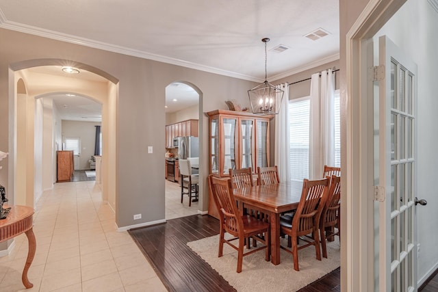2954 Smokey Forest Ln, Spring, TX 77386 - dining room with arched walkways, healthy amount of natural light, ornamental molding, a chandelier, and light tile patterned floors