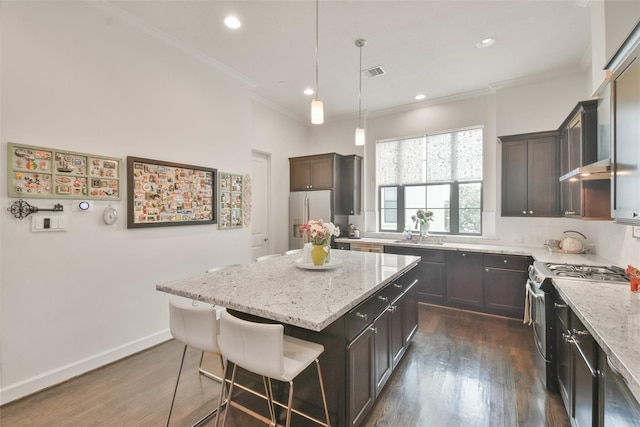 3937 Law St, Houston, TX 77005 - kitchen with stainless steel appliances, ornamental molding, light stone countertops, a center island, and dark wood finished floors