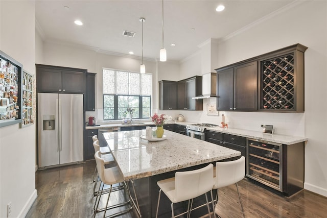 3937 Law St, Houston, TX 77005 - kitchen with appliances with stainless steel finishes, wine cooler, crown molding, light stone counters, and a kitchen bar