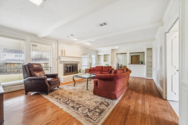 15718 Craighurst Dr, Houston, TX 77059 - living room featuring wood finished floors, beam ceiling, a brick fireplace, a textured ceiling, and crown molding
