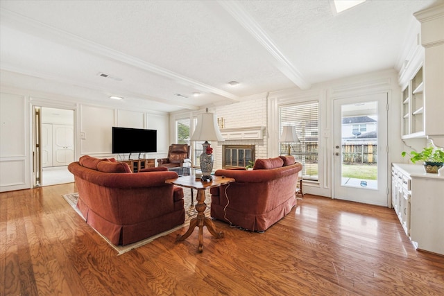 15718 Craighurst Dr, Houston, TX 77059 - living room with light wood-style floors, a textured ceiling, a fireplace, beam ceiling, and ornamental molding