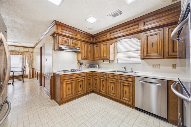 15718 Craighurst Dr, Houston, TX 77059 - kitchen featuring appliances with stainless steel finishes, brick patterned floors, under cabinet range hood, brown cabinets, and crown molding