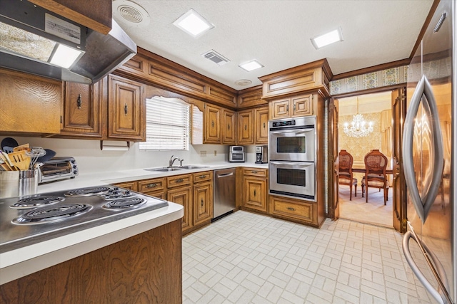 15718 Craighurst Dr, Houston, TX 77059 - kitchen featuring stainless steel appliances, wall chimney range hood, a chandelier, brown cabinets, and light countertops