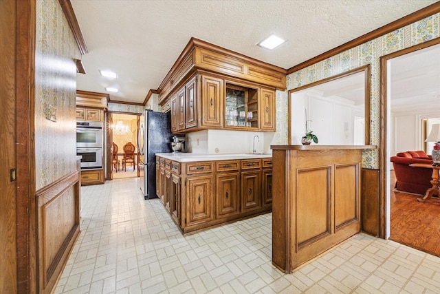 15718 Craighurst Dr, Houston, TX 77059 - kitchen featuring wallpapered walls, appliances with stainless steel finishes, brick patterned floors, ornamental molding, and light countertops