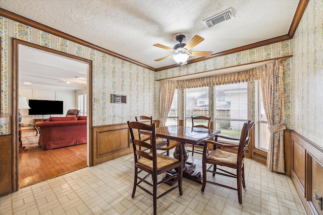 15718 Craighurst Dr, Houston, TX 77059 - dining room featuring wallpapered walls, a wainscoted wall, brick patterned floors, crown molding, and a ceiling fan