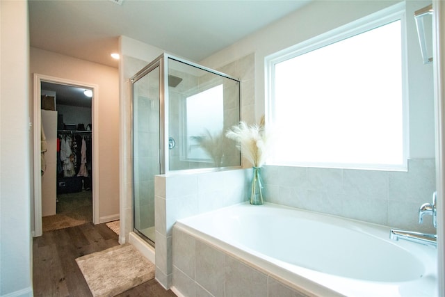 22118 Great Royal Ln, Houston, TX 77073 - bathroom with a garden tub, a shower stall, a walk in closet, and wood finished floors