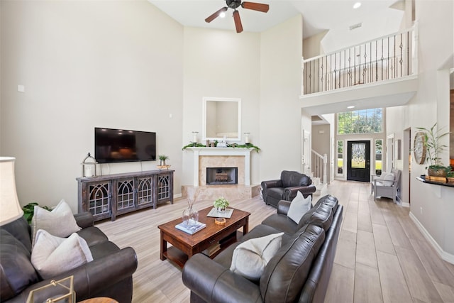 18882 Mystic Pt, Montgomery, TX 77356 - living area featuring a ceiling fan, a high ceiling, stairs, wood finished floors, and a premium fireplace