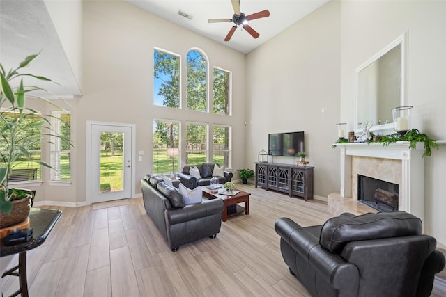 18882 Mystic Pt, Montgomery, TX 77356 - living room featuring a towering ceiling, a ceiling fan, a fireplace, and healthy amount of natural light