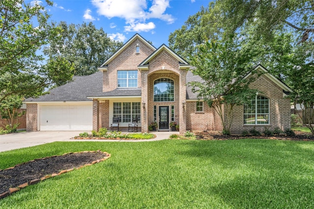 18882 Mystic Pt, Montgomery, TX 77356 - traditional-style home featuring concrete driveway, a front lawn, brick siding, and an attached garage