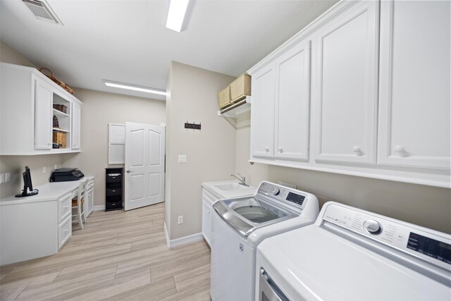 18882 Mystic Pt, Montgomery, TX 77356 - washroom featuring washing machine and clothes dryer, cabinet space, and light wood finished floors