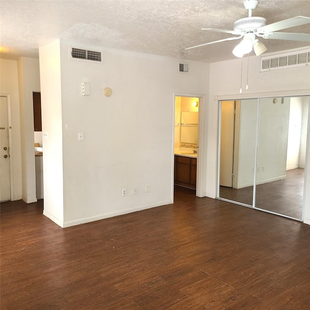 2021 Spenwick Dr Unit 511, Houston, TX 77055 - unfurnished bedroom featuring dark wood-style floors, a closet, ensuite bathroom, a ceiling fan, and a textured ceiling