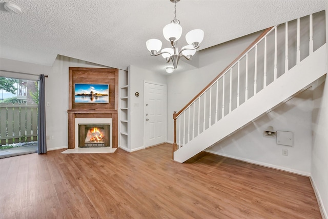 2120 El Paseo St Unit 501, Houston, TX 77054 - entryway with a textured ceiling, wood finished floors, a chandelier, stairs, and a fireplace with flush hearth