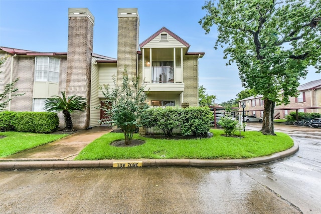 2120 El Paseo St Unit 501, Houston, TX 77054 - view of front facade featuring a balcony, brick siding, a chimney, and a front yard