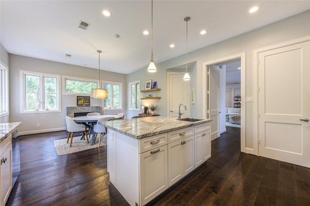 1121 Lashbrook Dr, Houston, TX 77077 - kitchen with white cabinets, light stone countertops, dark wood-style floors, recessed lighting, and pendant lighting