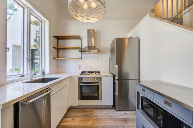 1121 Lashbrook Dr, Houston, TX 77077 - kitchen with stainless steel appliances, wall chimney range hood, white cabinetry, light wood-style floors, and open shelves