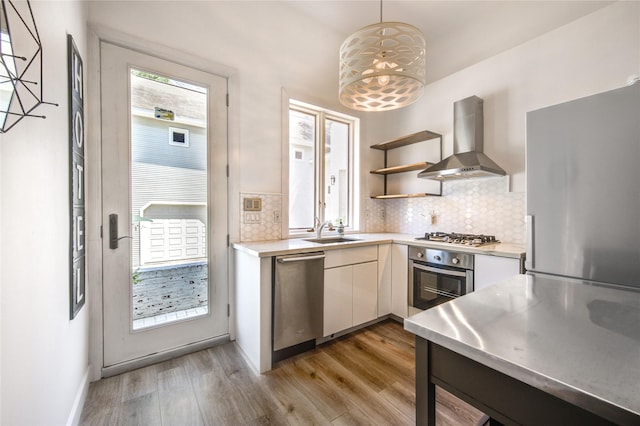 1121 Lashbrook Dr, Houston, TX 77077 - kitchen with wall chimney exhaust hood, stainless steel appliances, light countertops, and light wood finished floors